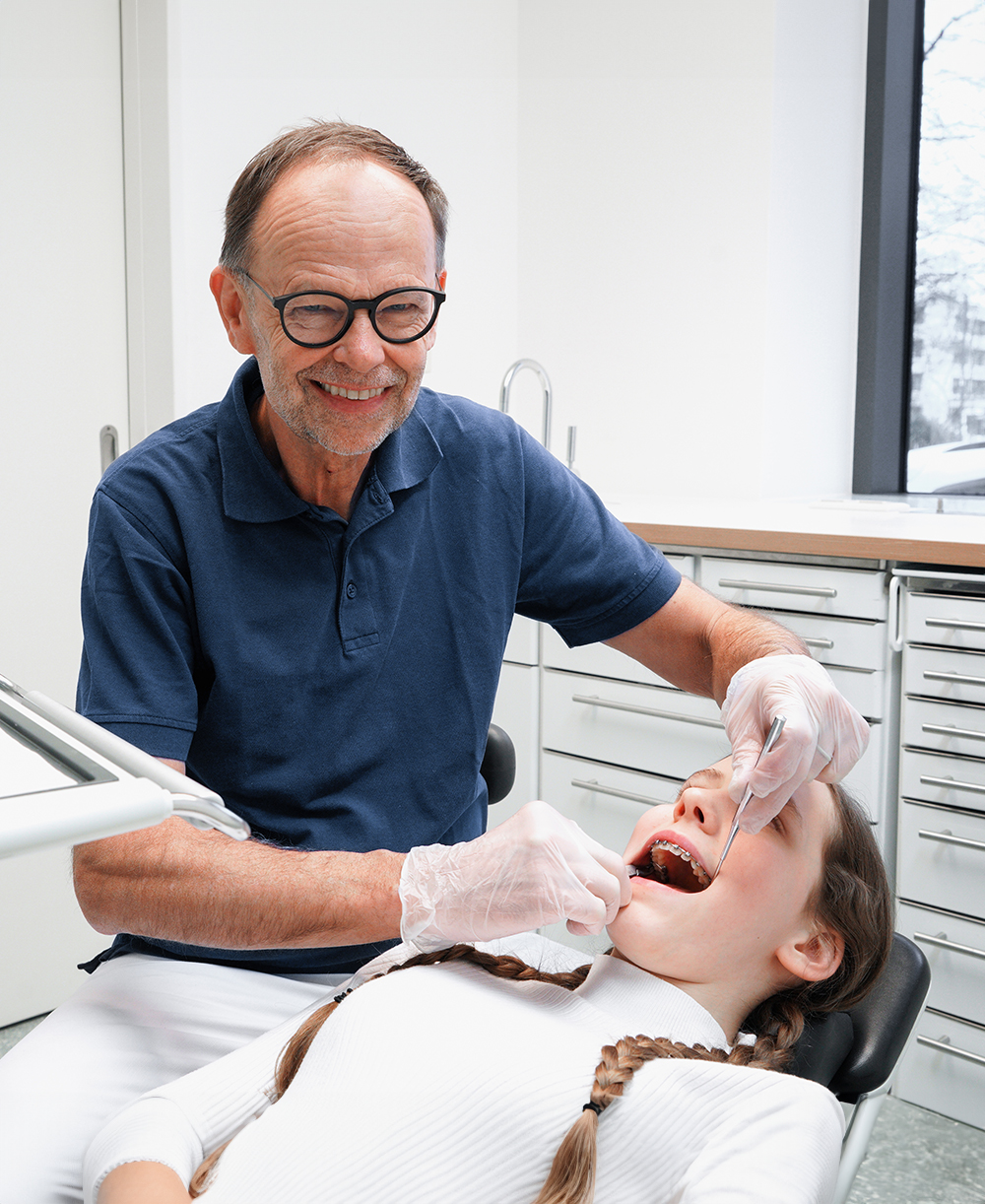 Kieferorthopde untersucht Jugendliche in der Praxis